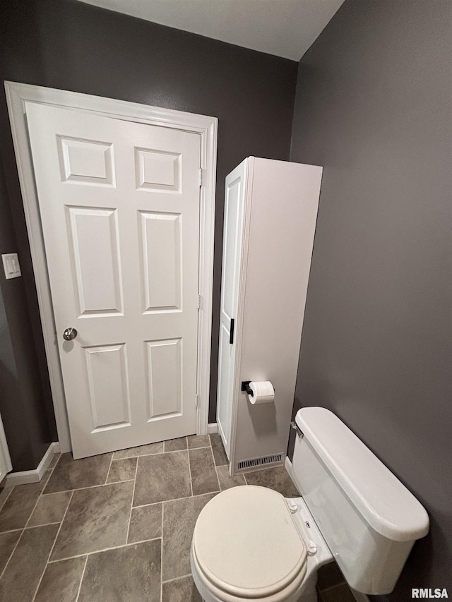 bathroom with baseboards and toilet