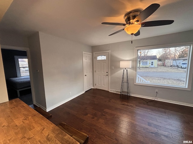 entryway with dark wood-type flooring, baseboards, and a ceiling fan