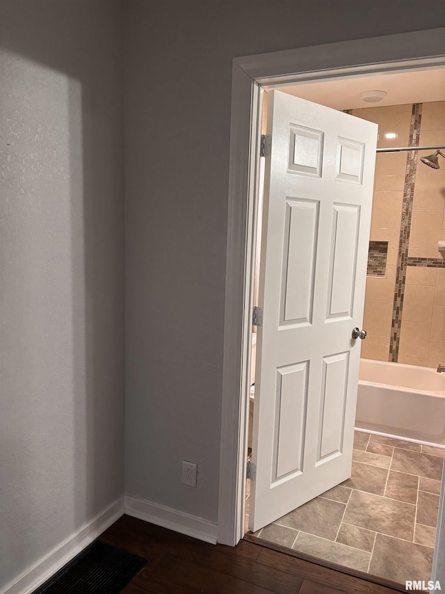 full bathroom featuring tub / shower combination and baseboards