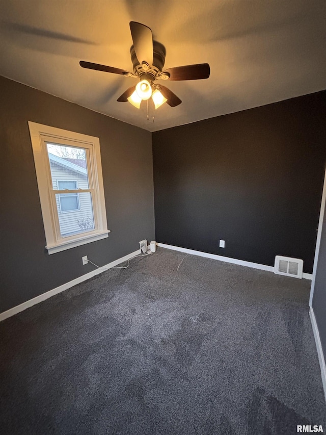 spare room with ceiling fan, baseboards, visible vents, and dark carpet