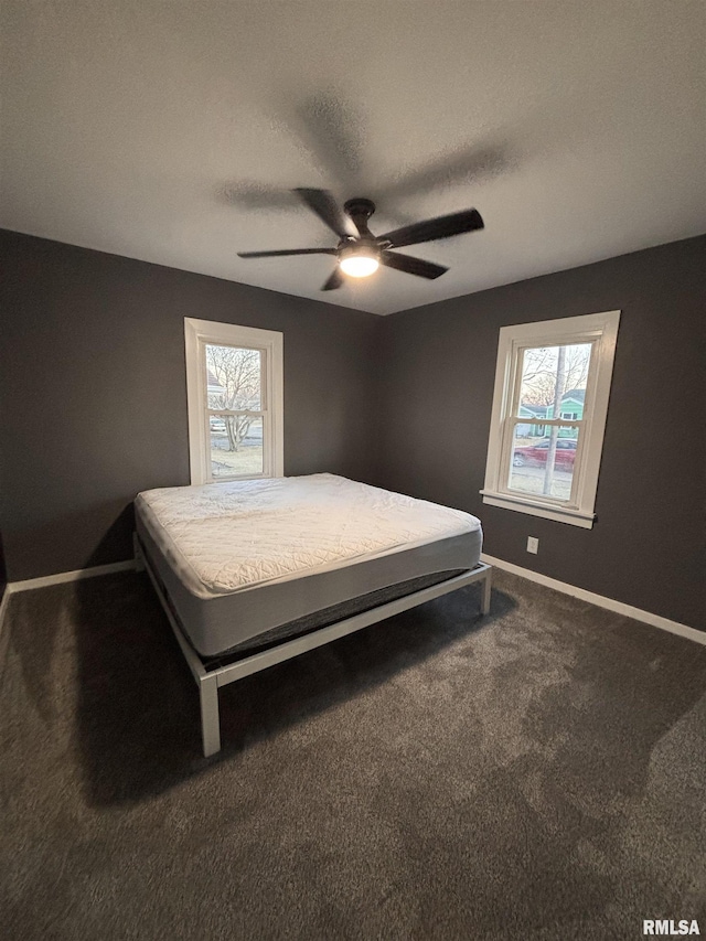 bedroom featuring multiple windows, baseboards, and carpet flooring