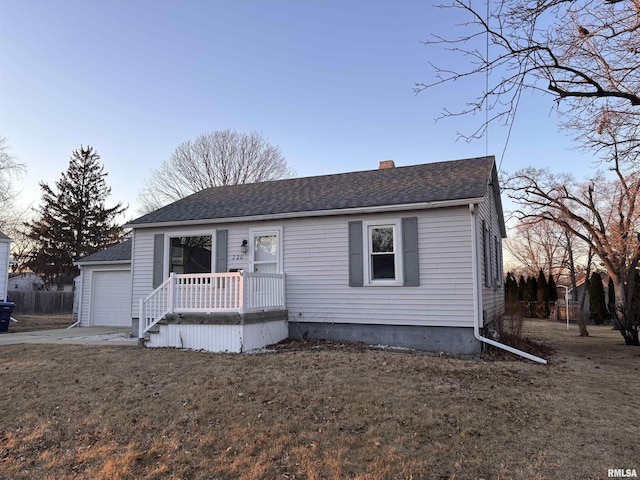 view of front of house with a chimney, a shingled roof, a garage, driveway, and a front lawn