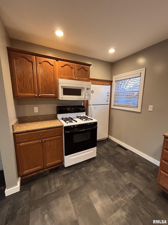 kitchen with recessed lighting, white appliances, brown cabinets, and baseboards