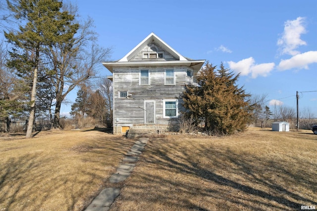 view of property exterior featuring an outbuilding, a lawn, and a shed