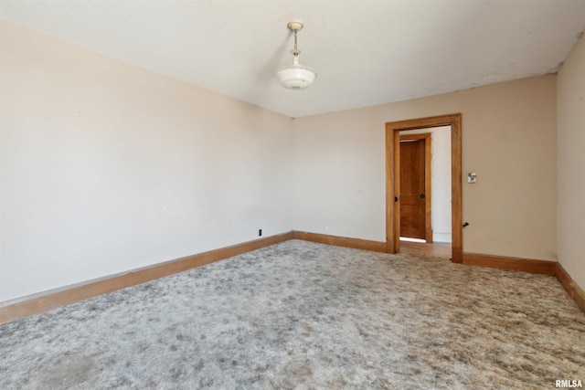 carpeted empty room featuring baseboards