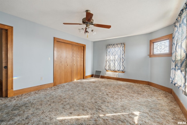 unfurnished bedroom with a ceiling fan, baseboards, a closet, and carpet floors