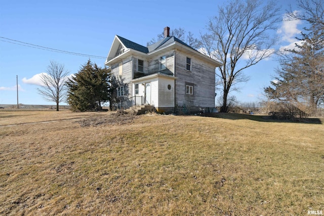 view of home's exterior featuring a lawn and a chimney