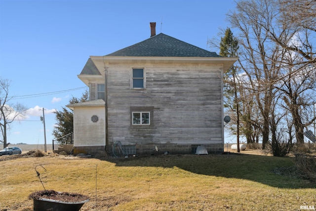 view of property exterior with a lawn and roof with shingles