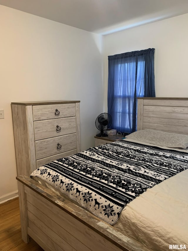 bedroom with baseboards and wood finished floors