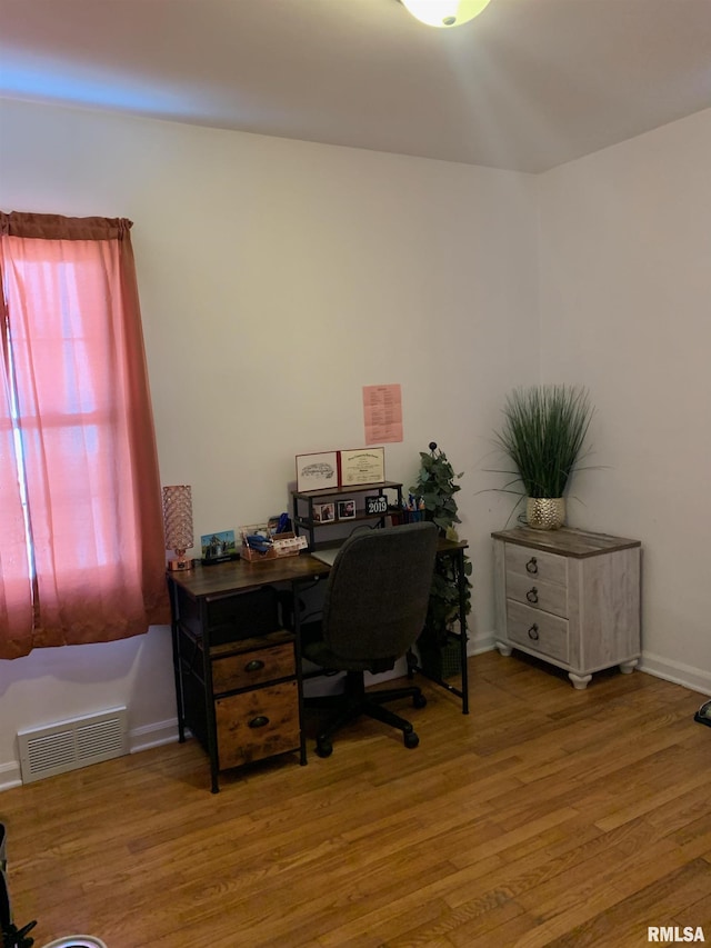 office with baseboards, visible vents, and wood finished floors