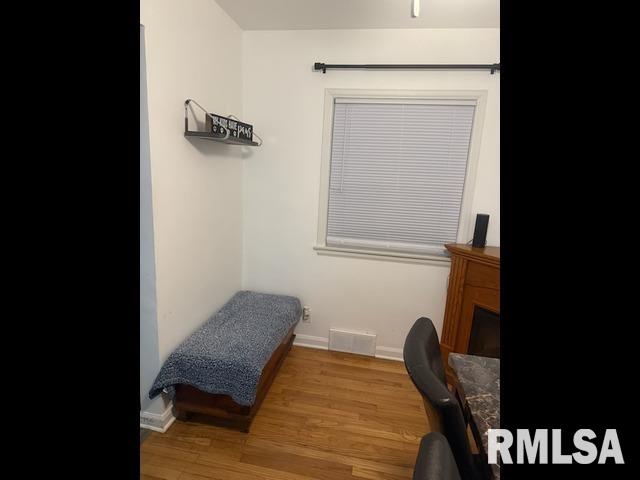 bedroom featuring visible vents, baseboards, and wood finished floors