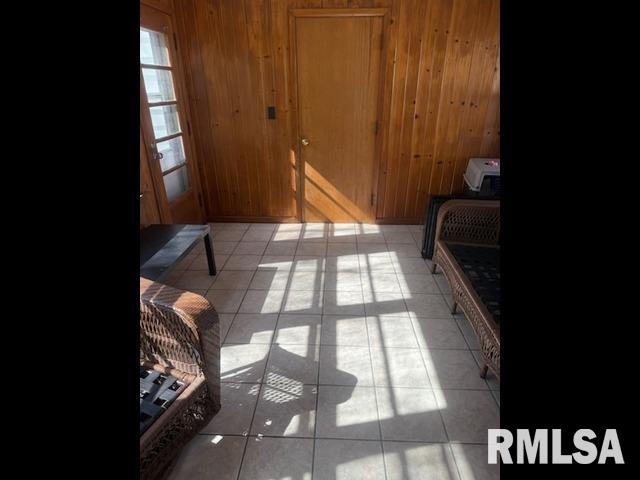 interior space featuring wooden walls and light tile patterned flooring