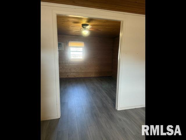 hall featuring dark wood-style flooring, wood ceiling, and baseboards