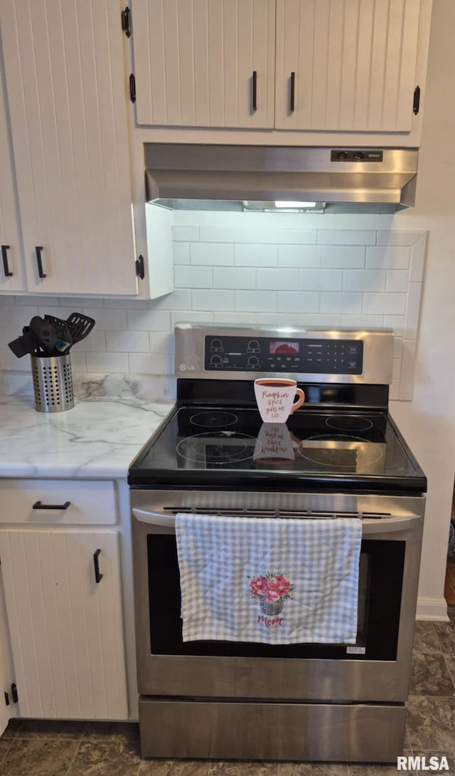 kitchen featuring backsplash, electric range, white cabinets, light stone countertops, and extractor fan