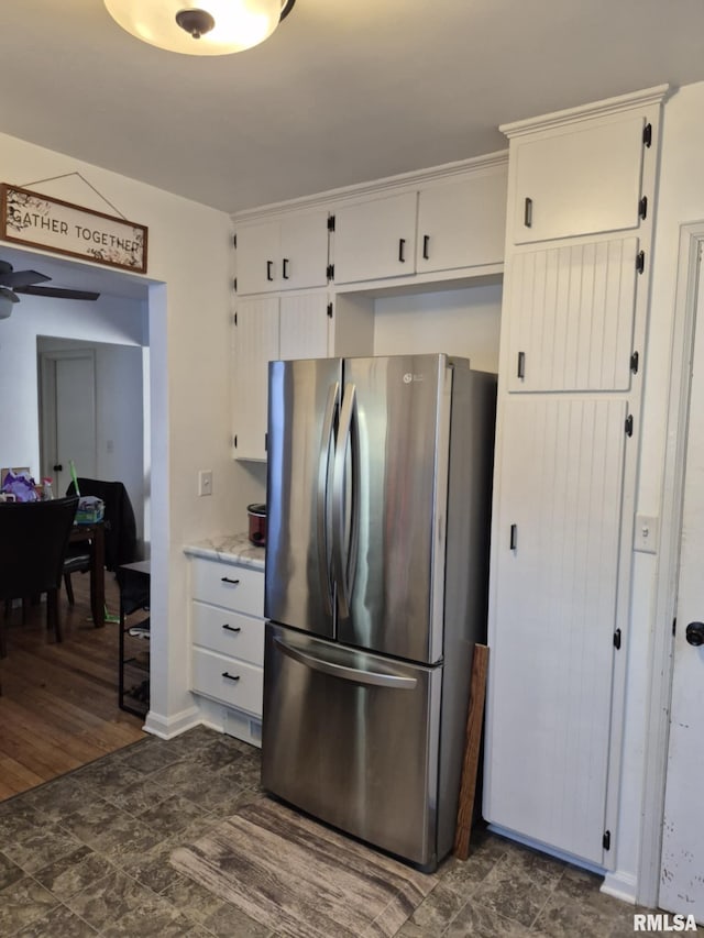 kitchen with white cabinetry, a ceiling fan, and freestanding refrigerator