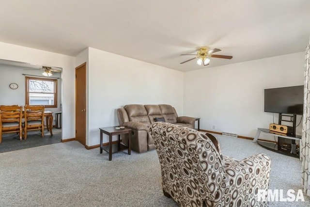 living area featuring carpet floors, ceiling fan, visible vents, and baseboards