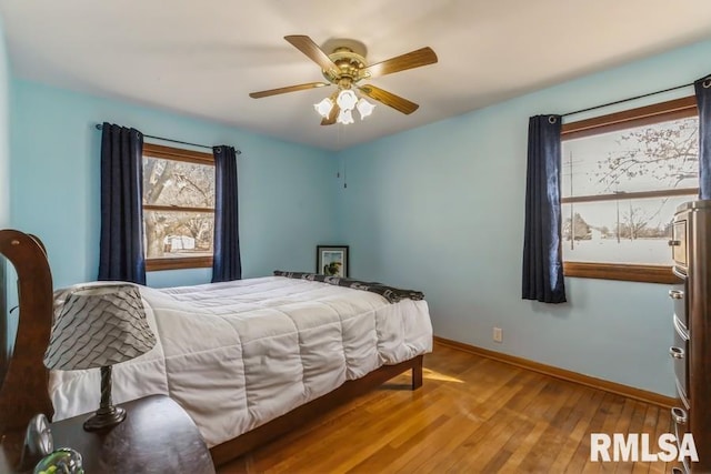 bedroom with hardwood / wood-style flooring, ceiling fan, and baseboards