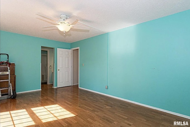 unfurnished bedroom featuring baseboards, a textured ceiling, and wood finished floors
