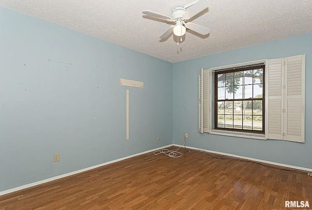 spare room with a ceiling fan, wood finished floors, baseboards, and a textured ceiling