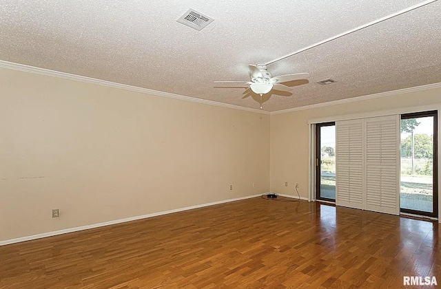 unfurnished room with visible vents, a textured ceiling, crown molding, and wood finished floors