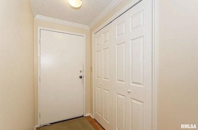 entryway with a textured ceiling and crown molding