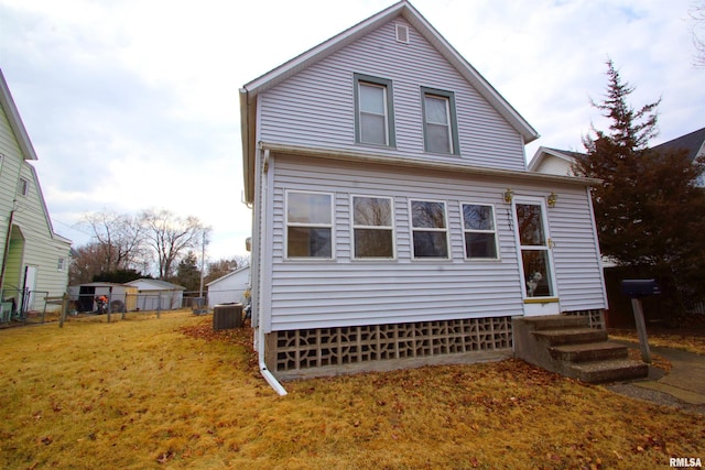 view of front of home with entry steps, fence, cooling unit, and a front yard