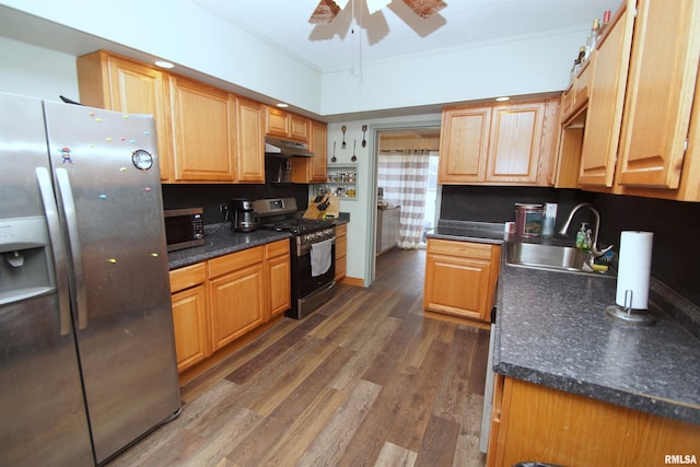 kitchen with dark wood finished floors, appliances with stainless steel finishes, crown molding, under cabinet range hood, and a sink