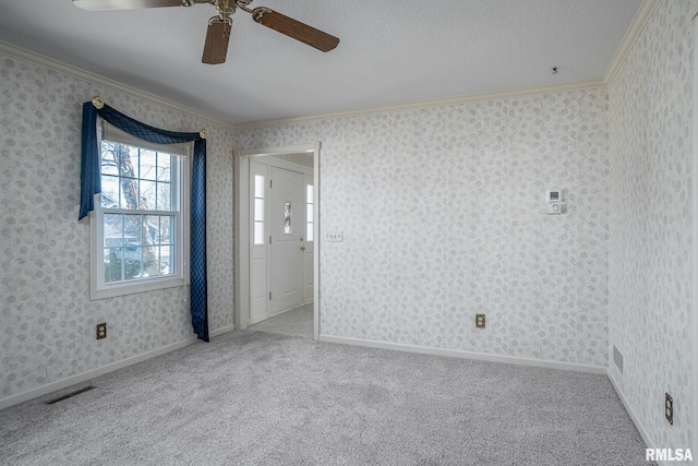 carpeted spare room with visible vents, crown molding, a textured ceiling, and wallpapered walls