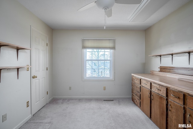 interior space featuring light carpet, visible vents, baseboards, and a ceiling fan