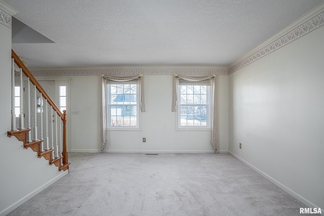 carpeted spare room with a textured ceiling, stairway, and baseboards