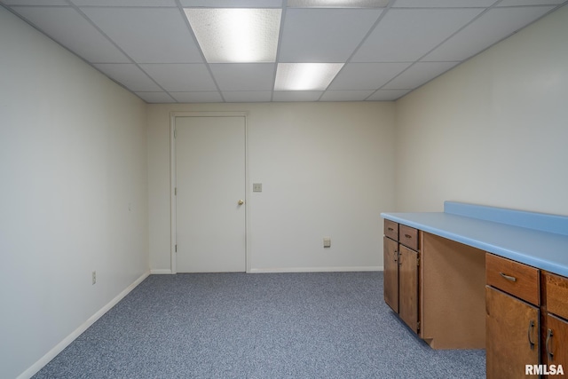 empty room featuring light carpet, a paneled ceiling, and baseboards