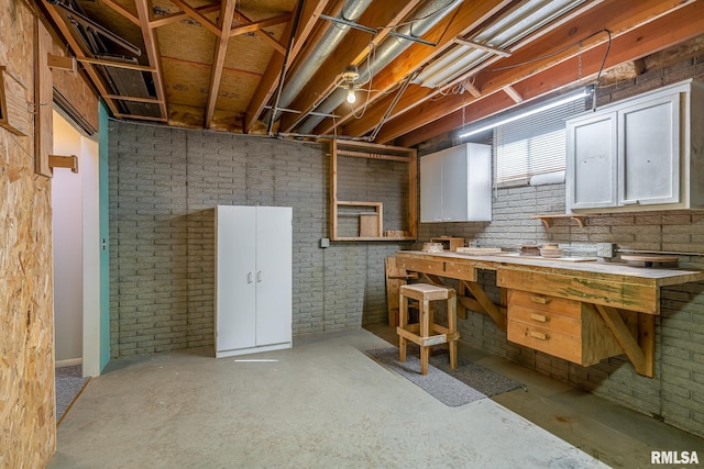 unfinished basement featuring brick wall and a workshop area