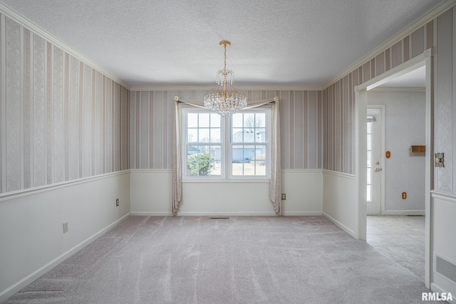 carpeted spare room with wallpapered walls, baseboards, a chandelier, and a textured ceiling