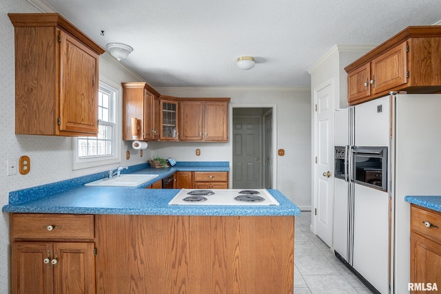 kitchen with brown cabinetry, white appliances, and a sink