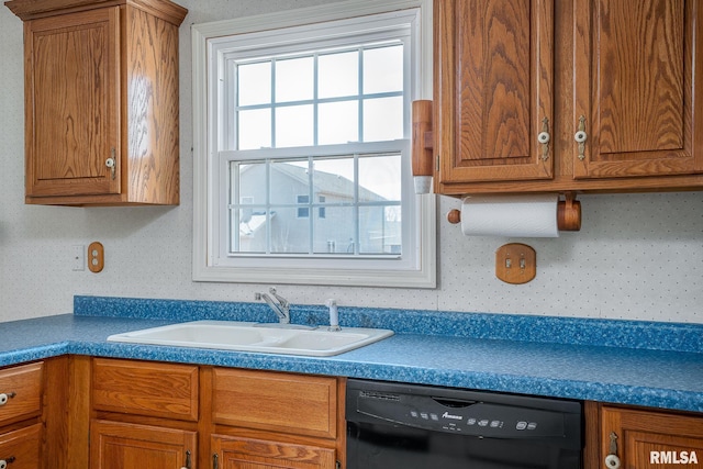 kitchen with wallpapered walls, black dishwasher, dark countertops, brown cabinets, and a sink