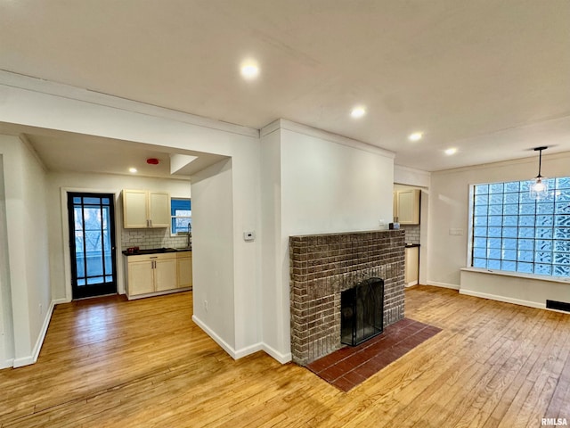 unfurnished living room featuring light wood finished floors, a fireplace, and baseboards