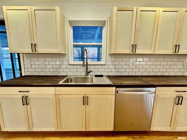 kitchen featuring a sink, wood counters, decorative backsplash, and stainless steel dishwasher