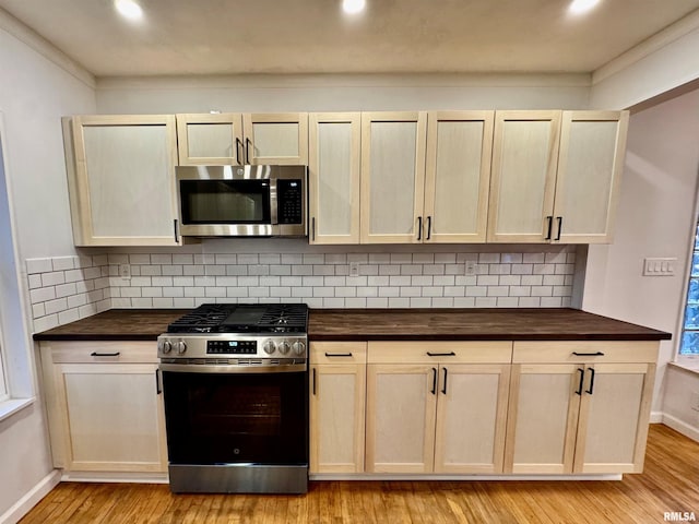 kitchen featuring stainless steel appliances, wood counters, and light wood finished floors