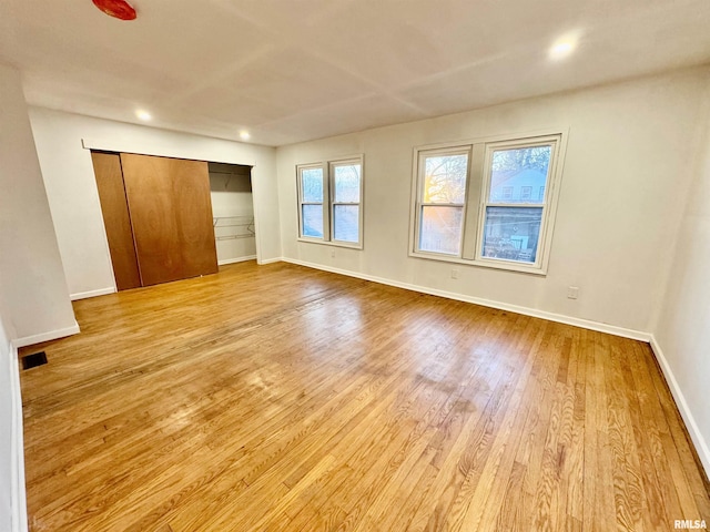 unfurnished bedroom featuring recessed lighting, a closet, visible vents, wood finished floors, and baseboards