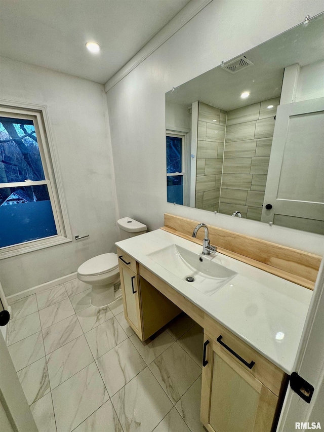 bathroom featuring toilet, vanity, visible vents, baseboards, and marble finish floor