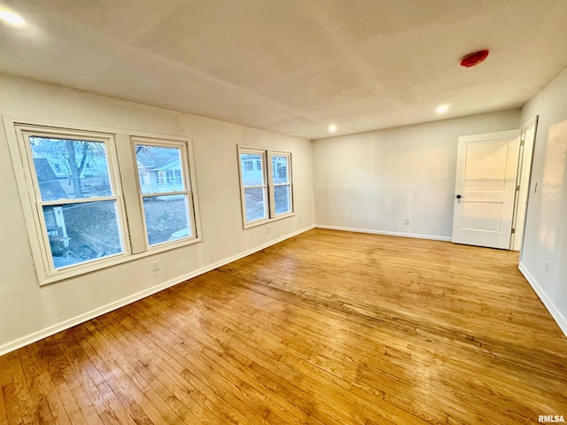 unfurnished room with recessed lighting, hardwood / wood-style flooring, and baseboards