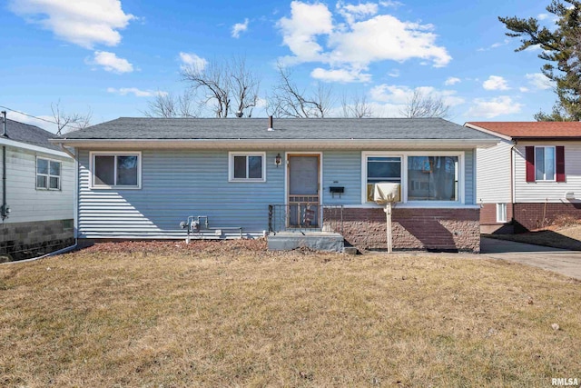 ranch-style home with a shingled roof and a front yard