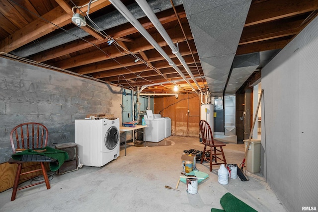 unfinished below grade area featuring water heater and washer and dryer