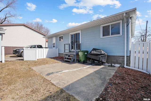 back of house featuring entry steps and fence