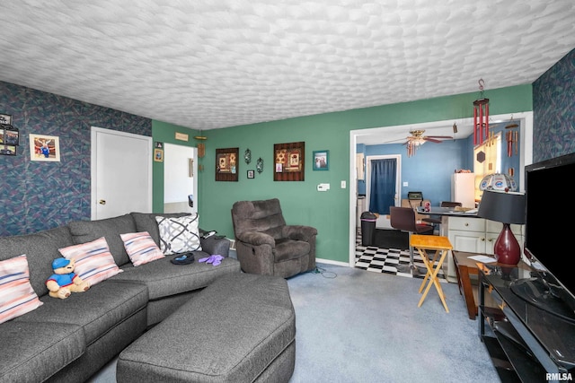 living area featuring wallpapered walls, baseboards, a ceiling fan, a textured ceiling, and carpet floors