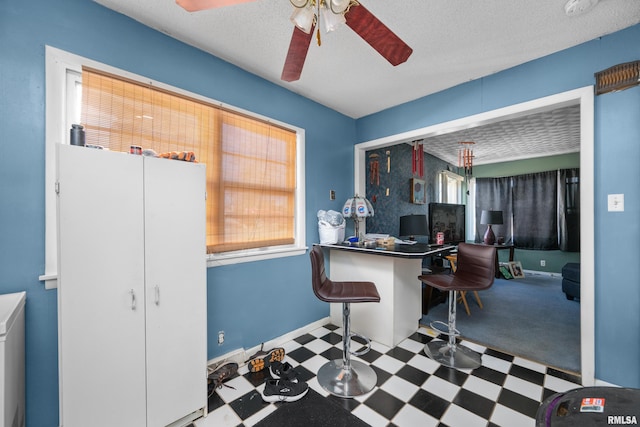 office area with baseboards, a textured ceiling, a ceiling fan, and tile patterned floors