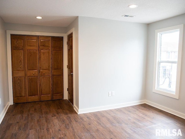 unfurnished bedroom with dark wood-style floors, recessed lighting, visible vents, a textured ceiling, and baseboards