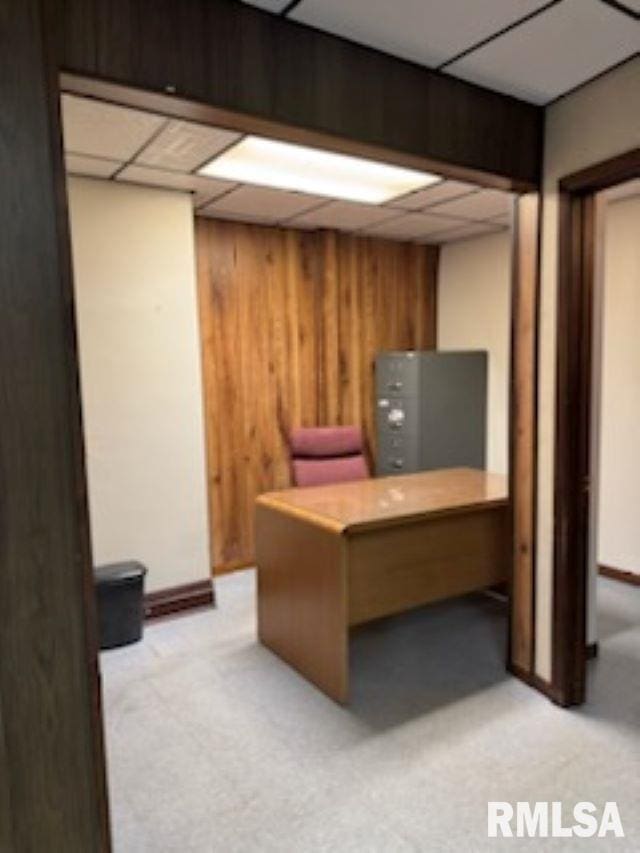 office space with wood walls and a paneled ceiling