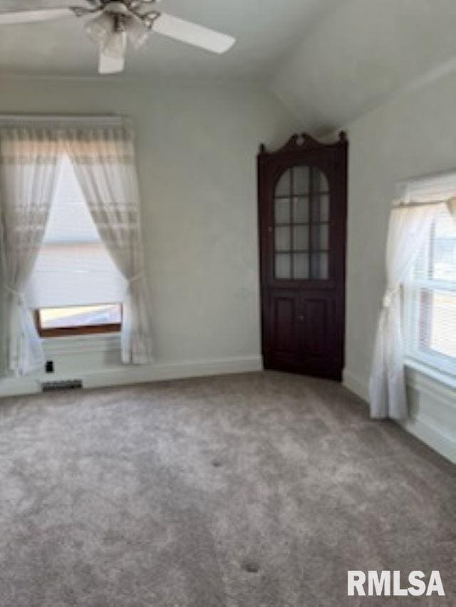 interior space with lofted ceiling, ceiling fan, and baseboards