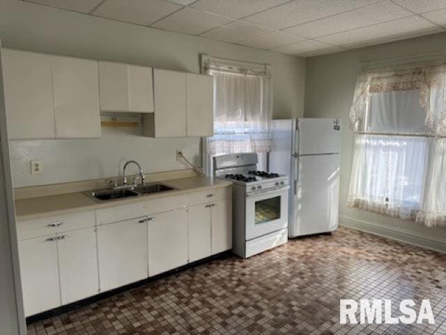 kitchen featuring light countertops, white appliances, a sink, and a wealth of natural light